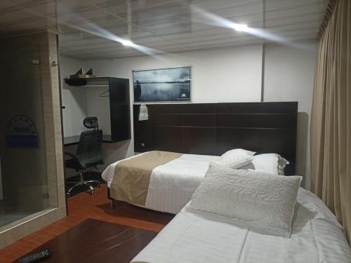 a hotel room with a bed and a desk at SUITE SANTA LUCIA HOTEL BOUTIQUE in Sogamoso