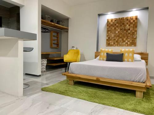 a bedroom with a bed and a yellow chair at Acogedora suite con entrada independiente in Minatitlán