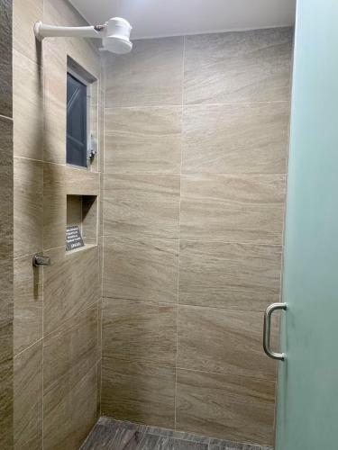 a bathroom with a shower with a glass door at Acogedora suite con entrada independiente in Minatitlán