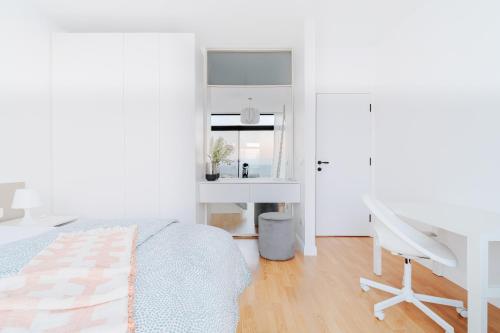 a white bedroom with a bed and a desk at Nabeel Homes - Seaview Building - 3 Units in Gleem in Alexandria