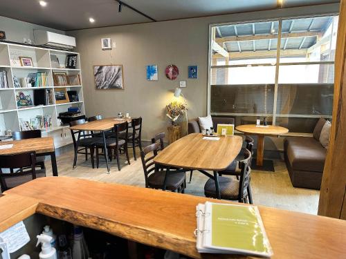 a restaurant with tables and chairs in a room at RONENAI BASE in Biei