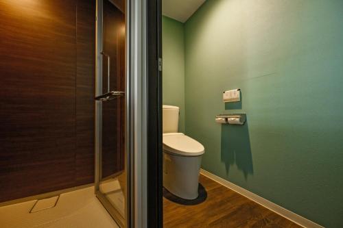 a bathroom with a toilet and a shower at TWIN LINE HOTEL YANBARU OKINAWA JAPAN Formerly Okinawa Suncoast Hotel in Nago
