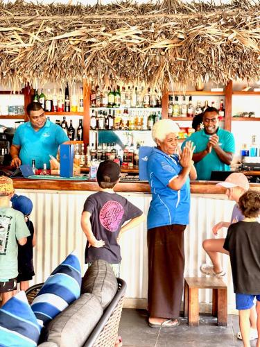 a woman standing at a bar with a group of people at Blue Lagoon Beach Resort in Nacula Island