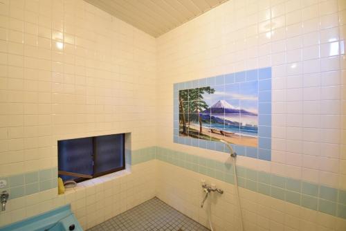 baño con ducha con una foto en la pared en 庵治みなと番所, en Takamatsu