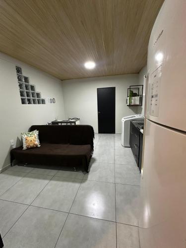 a living room with a couch and a refrigerator at LOFT Completo - próximo ao Centro com Ar Condicionado in Joinville