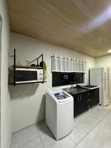 a kitchen with a stove and a microwave at LOFT Completo - próximo ao Centro com Ar Condicionado in Joinville