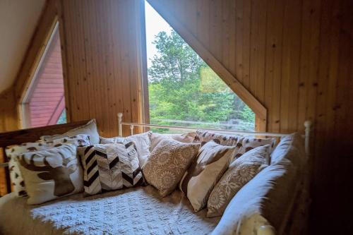 a large couch in a room with a window at Solar powered log cabin with mountain views, 3acres in Lake Lure