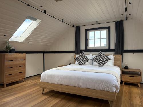 una camera con un grande letto e due finestre di The Podium Accommodation - Oatlands, Tasmania a Oatlands