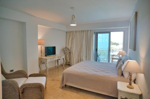 a bedroom with a bed and a couch and a television at The Cliff View in Cupecoy