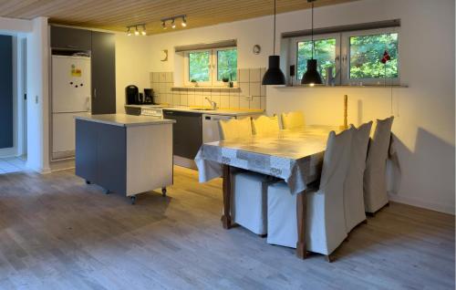 a kitchen with a large wooden table and chairs at 2 Bedroom Cozy Home In Ebeltoft in Øksenmølle