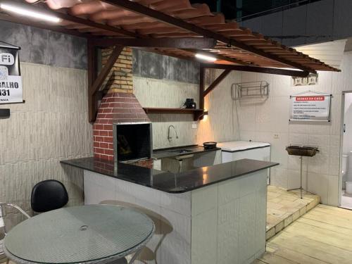 eine Küche mit Theke und Tisch in einem Raum in der Unterkunft Casa Moderna em Nossa Senhora do Ó, Porto de Galinhas! in Ipojuca