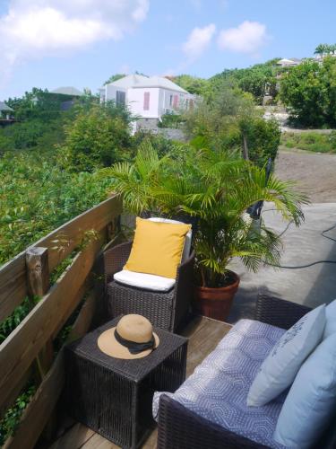 a balcony with wicker chairs and a yellow pillow at Brisa Del Mar - Camarouche in Quartier de Lorient