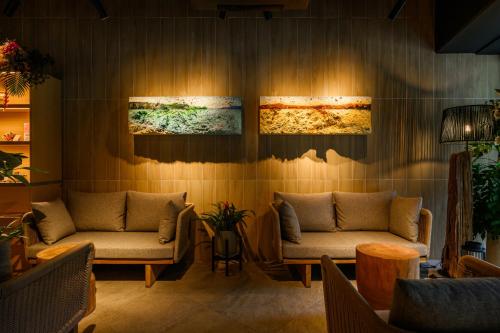 a lobby with two couches and paintings on the wall at TWIN LINE HOTEL YANBARU OKINAWA JAPAN Formerly Okinawa Suncoast Hotel in Nago