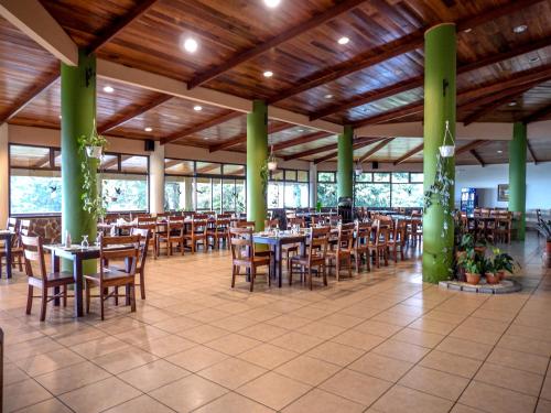a dining room with tables and chairs in a building at Hotel Montaña Monteverde in Monteverde Costa Rica