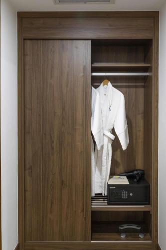 a wardrobe with a white suit and a radio at Miracle Luxury Nha Trang in Nha Trang