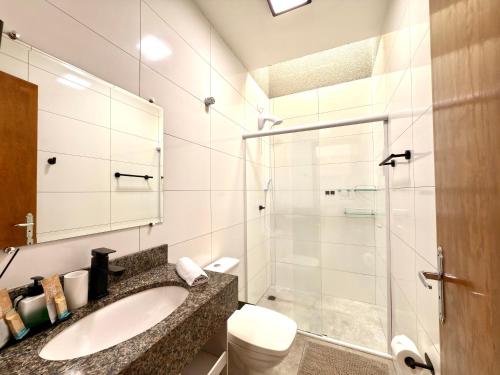 a bathroom with a sink and a shower at Casa com 2 quartos, ar-condicionado, Wi-fi e estacionamento in Matinhos