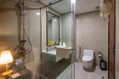 a bathroom with a shower and a toilet and a sink at Miracle Luxury Nha Trang in Nha Trang