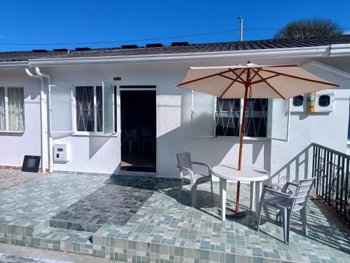 a table and chairs with an umbrella in front of a house at Hermosa casa de sol Aragon 1 in Flandes