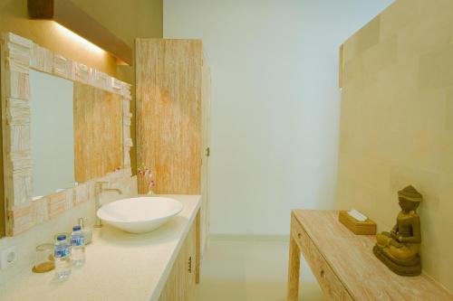 a bathroom with a white sink and a mirror at Villa Padma Ubud in Ubud