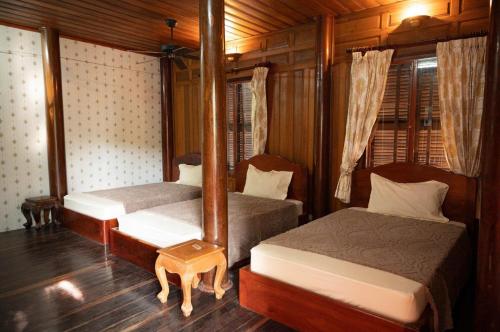 a bedroom with two beds and a mirror at Yellow Sun Kep in Kep