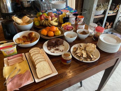 a wooden table with many plates of food on it at Casa da Praia in São José do Norte