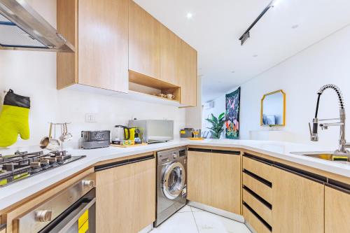 a kitchen with wooden cabinets and a washer and dryer at Nabeel Homes - Seaview Building - 3 Units in Gleem in Alexandria