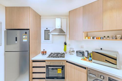 a kitchen with wooden cabinets and a refrigerator at Nabeel Homes - Seaview Building - 3 Units in Gleem in Alexandria