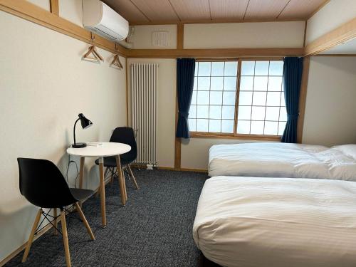 a hotel room with two beds and a desk and a table at RONENAI BASE - Vacation STAY 87314v in Shibinai