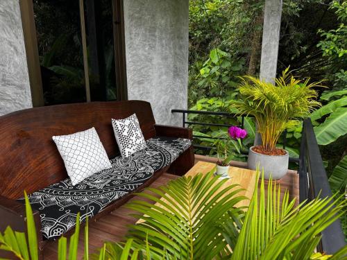 un banco de madera sentado en un patio con plantas en Bantai Hideaway - House 2, en Ko Phangan