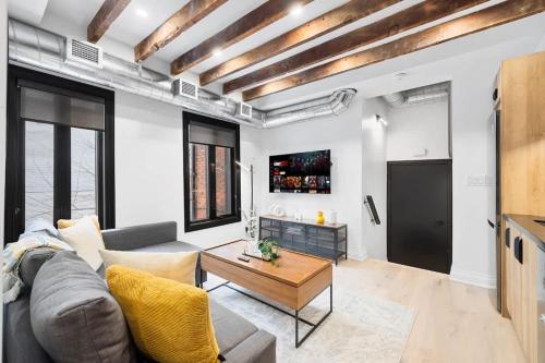 a living room with a couch and a table at Modern Parkdale Getaway 1-Bedroom Parking in Toronto