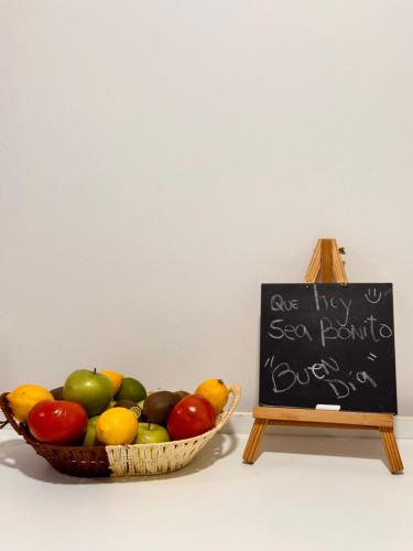 a bowl of fruit sitting next to a sign at Hostal B&B Coastal Natales in Puerto Natales