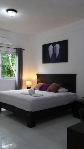 a bedroom with a large bed and a window at HOKAB in Cenote Azul