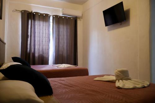 a room with two beds and a television on the wall at HOKAB in Cenote Azul