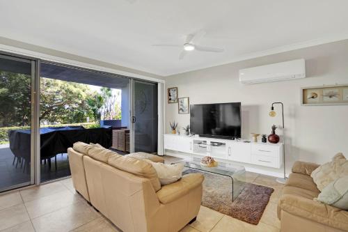 a living room with two couches and a tv at Reflections G01 On The Lake in Forster