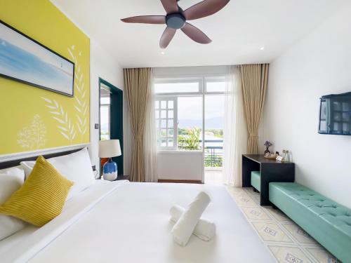 a bedroom with a large bed and a ceiling fan at Sujet Beach Hotel and Apartment Danang by Haviland in Da Nang
