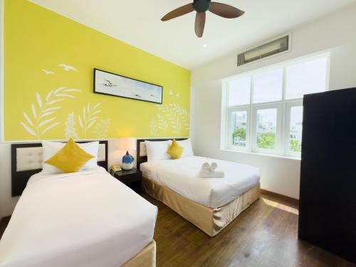 a bedroom with two beds and a ceiling fan at Sujet Beach Hotel and Apartment Danang by Haviland in Da Nang