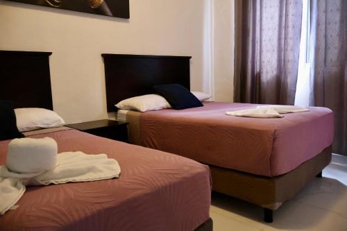 two beds in a hotel room with towels on them at HOKAB in Cenote Azul