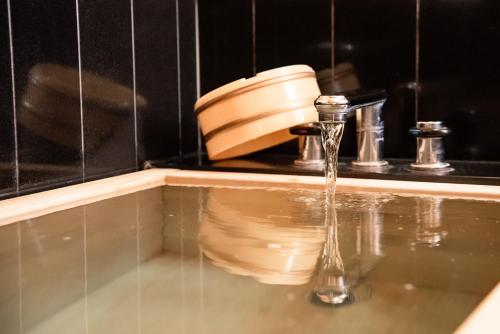 a bathroom sink with water running from a faucet at Luke Plaza Hotel in Nagasaki
