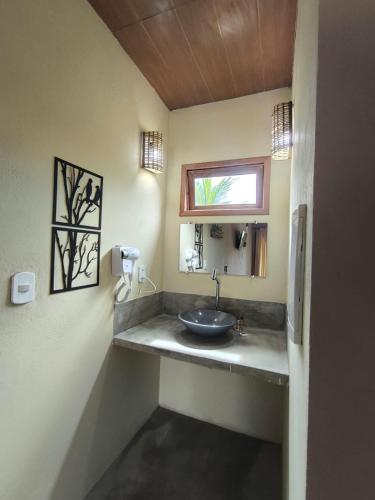 een badkamer met een wastafel en een raam bij Há Mar Chalés Corumbau in Prado