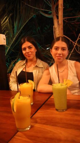 two women sitting at a table with drinks at HOKAB in Cenote Azul