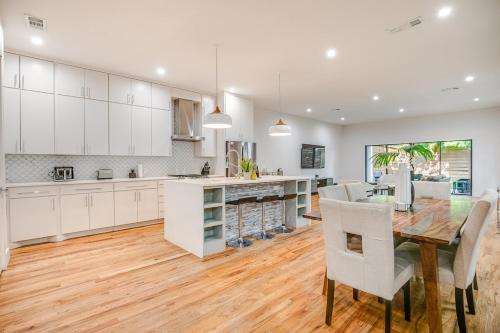 a kitchen with a wooden table and white cabinets at Uptown Dallas Modern Retreat in Dallas