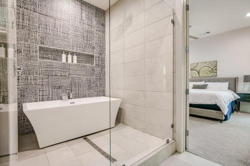 a bathroom with a shower and a tub and a bed at Uptown Dallas Modern Retreat in Dallas