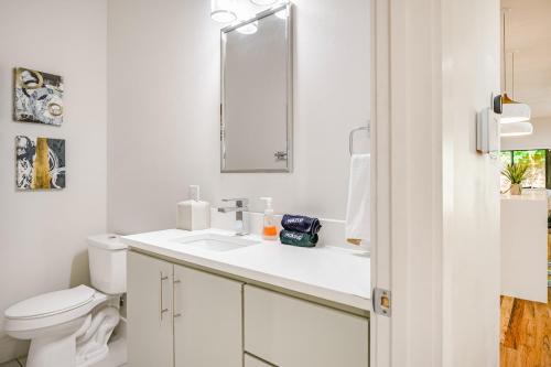 a white bathroom with a sink and a toilet at Uptown Dallas Modern Retreat in Dallas