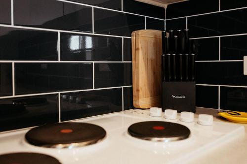 a kitchen counter with a stove top with a knife at Talina - History in the Heart of St Helens in St Helens