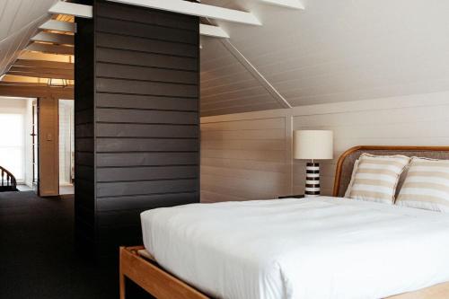 a bedroom with a white bed and a staircase at Talina - History in the Heart of St Helens in St Helens
