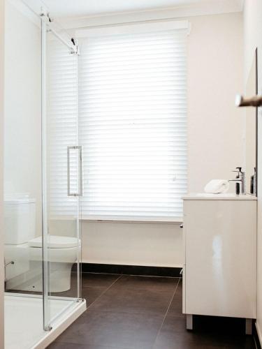 a bathroom with a glass shower and a toilet at Talina - History in the Heart of St Helens in St Helens