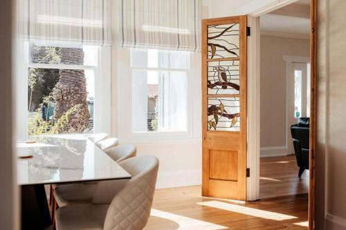 a dining room with a table and chairs and windows at Talina - History in the Heart of St Helens in St Helens