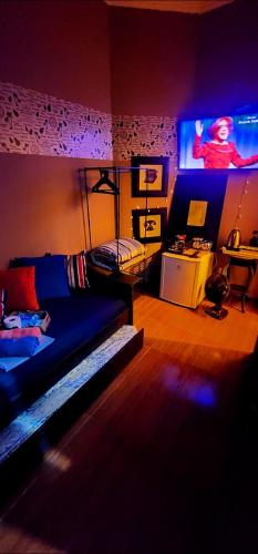 un salon avec un lit et une télévision dans l'établissement Mansão City Quarto Privativo, à Osasco