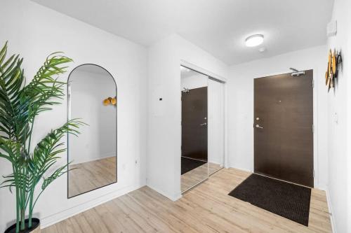 a hallway with two mirrors and a potted plant at Modern Lakefront Esc Stylish 2BR Condo with Patio in Toronto