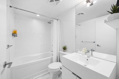 a white bathroom with a sink and a shower at Modern Lakefront Esc Stylish 2BR Condo with Patio in Toronto